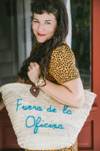 femme carrying rattan bag with the words fuera de la oficina on it embracing failure