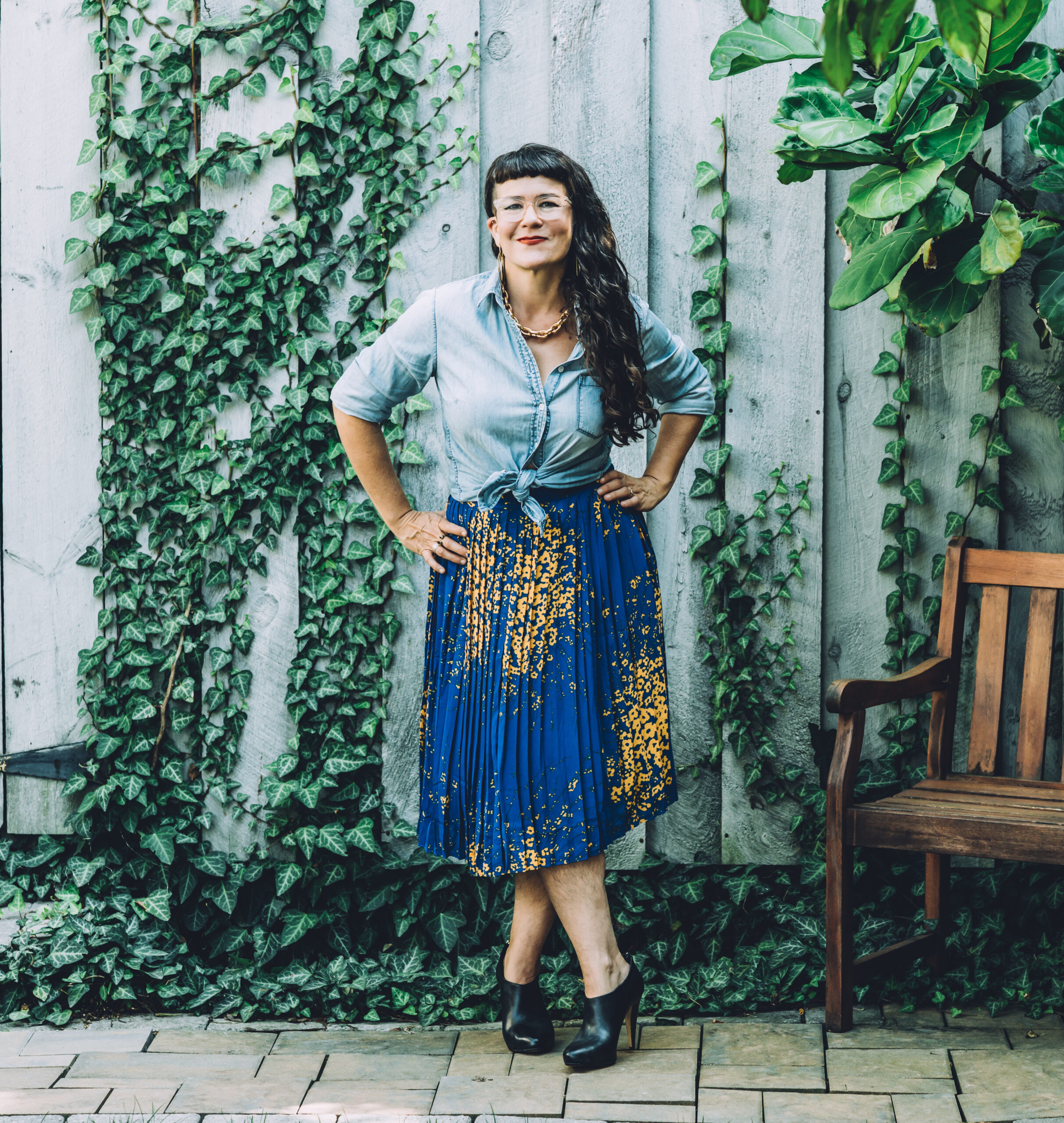 life coach victoria albina standing in front of an ivy-covered wall
